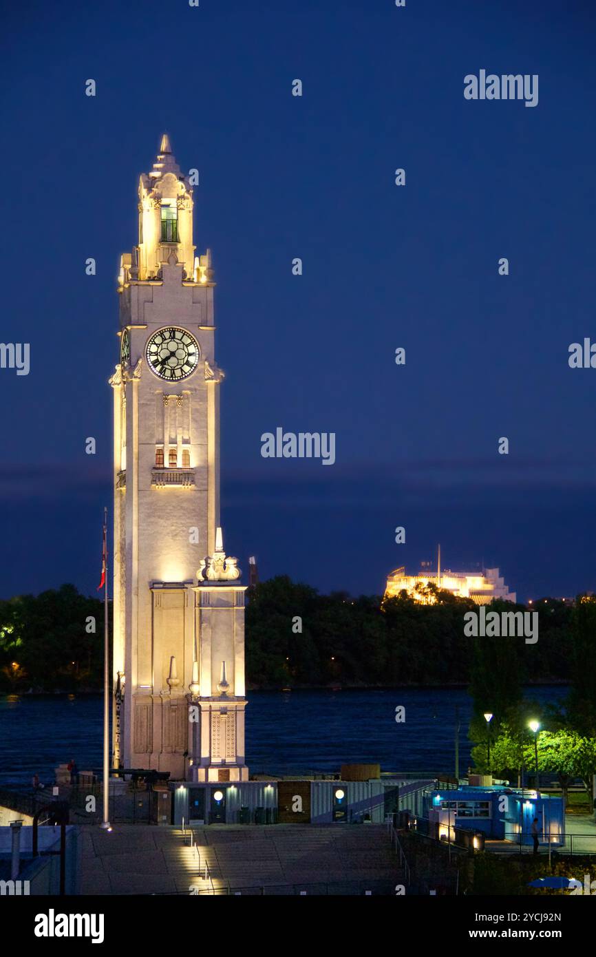 Torre dell'orologio del vecchio porto di Montreal illuminata sul fiume al tramonto Foto Stock