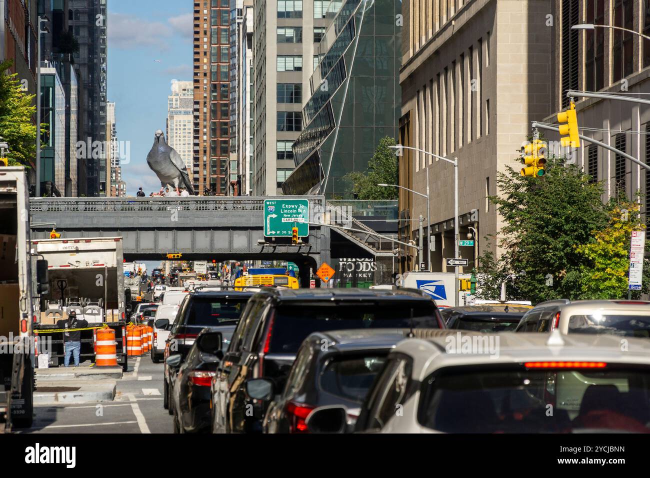 I lavoratori finiscono l'installazione di "Dinosaur" (2024) dell'artista Iván Argote che incombe sulla Tenth Avenue sulla High Line Spur a New York mercoledì 16 ottobre 2024. La scultura sovradimensionata, dipinta a mano e iperrealistica di alluminio fuso fa riferimento agli antenati del piccione, che si sono estinti milioni di anni fa. L'uccello gigante sarà in mostra fino alla primavera del 2026. (© Richard B. Levine) Foto Stock