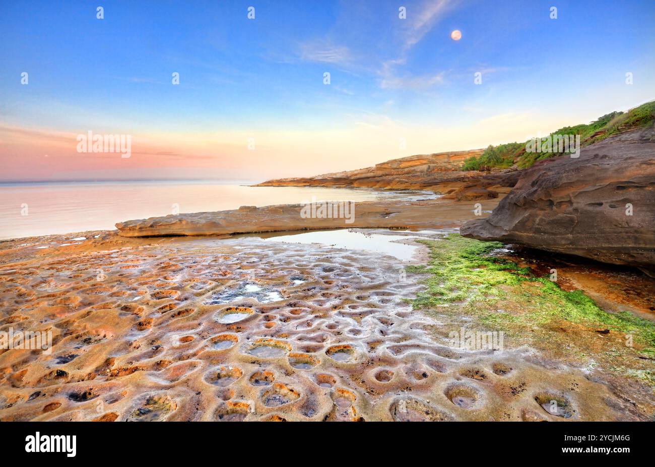 Alba a Botany Bay, la Perouse, Sydney Australia in una tranquilla mattinata d'estate, la luna splende ancora sopra lo strano cratere lunare come p Foto Stock