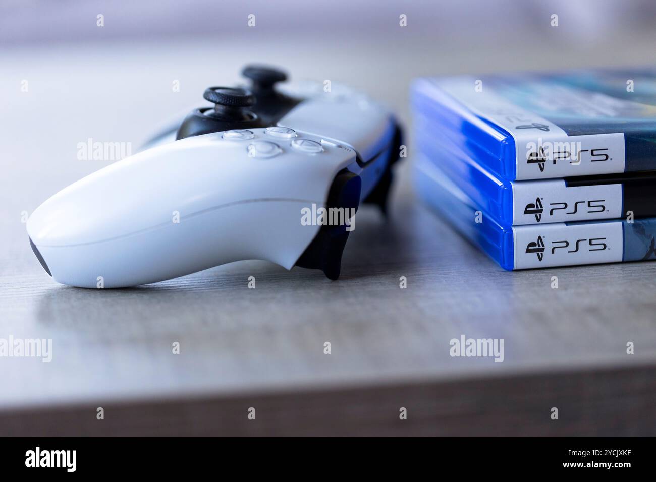 Brecht, Belgio - 3 ottobre 2024: Un controller per PlayStation 5 accanto alle custodie con il logo ps5. tutto è pronto per giocare un veto Foto Stock