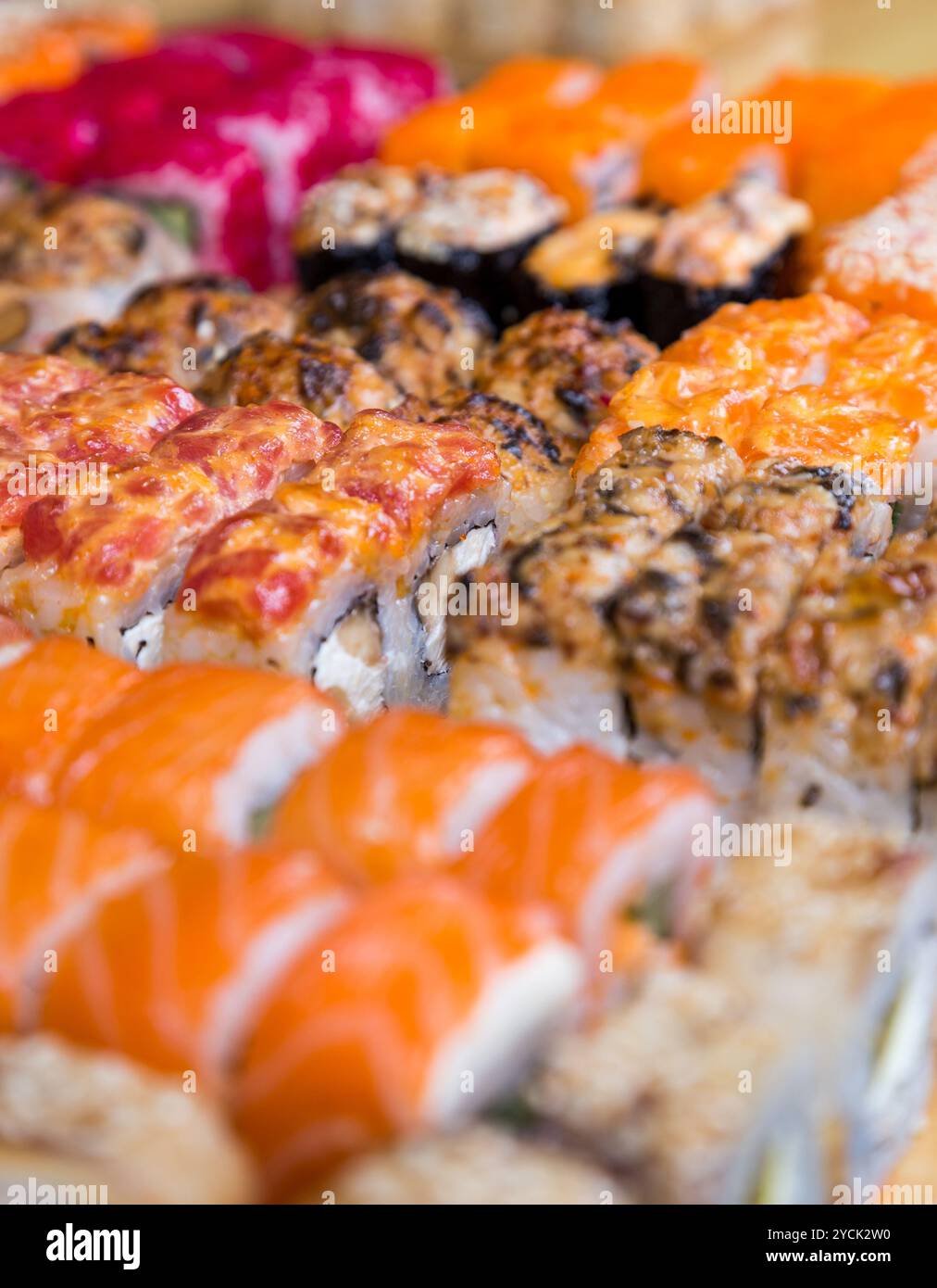 Sushi e panini assortiti su tavola di legno in luce buia Foto Stock