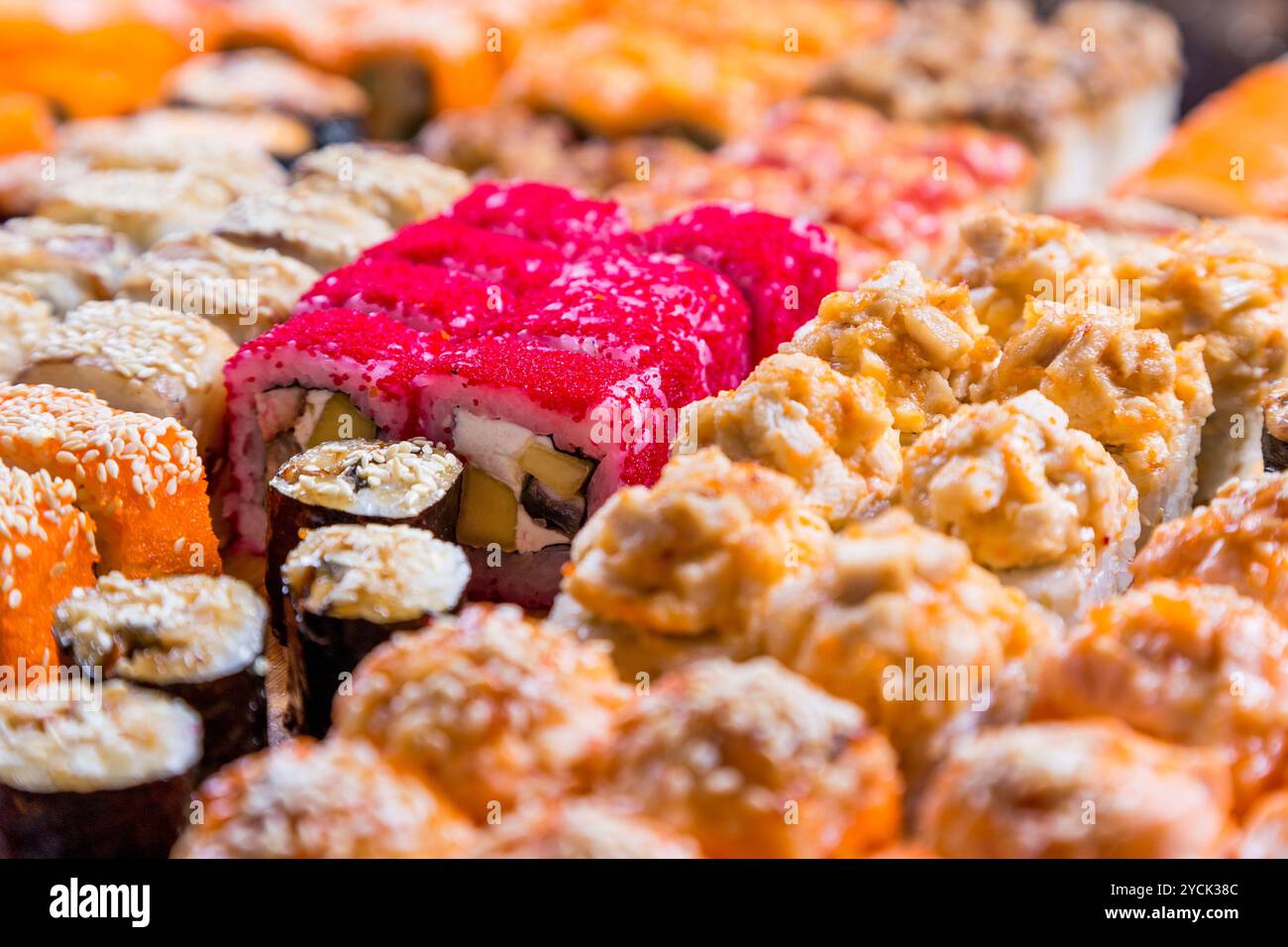 Sushi e panini assortiti su tavola di legno in luce buia Foto Stock