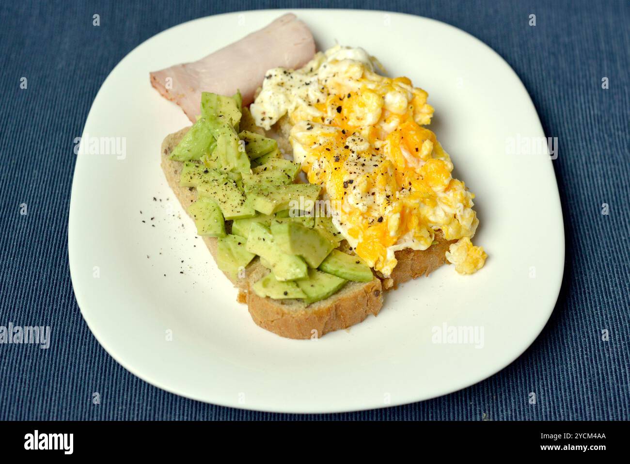 Colazione sana e nutriente con uova strapazzate e avocado schiacciato sul pane tostato dall'alto Foto Stock