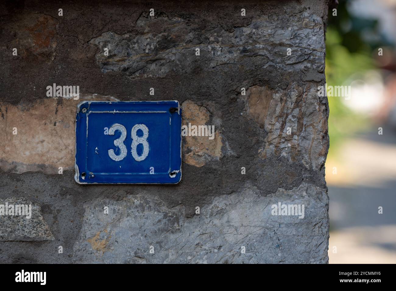 Numero 38 in blu: Numeri bianchi sulla piastra di metallo intorno all'angolo sfocato Foto Stock