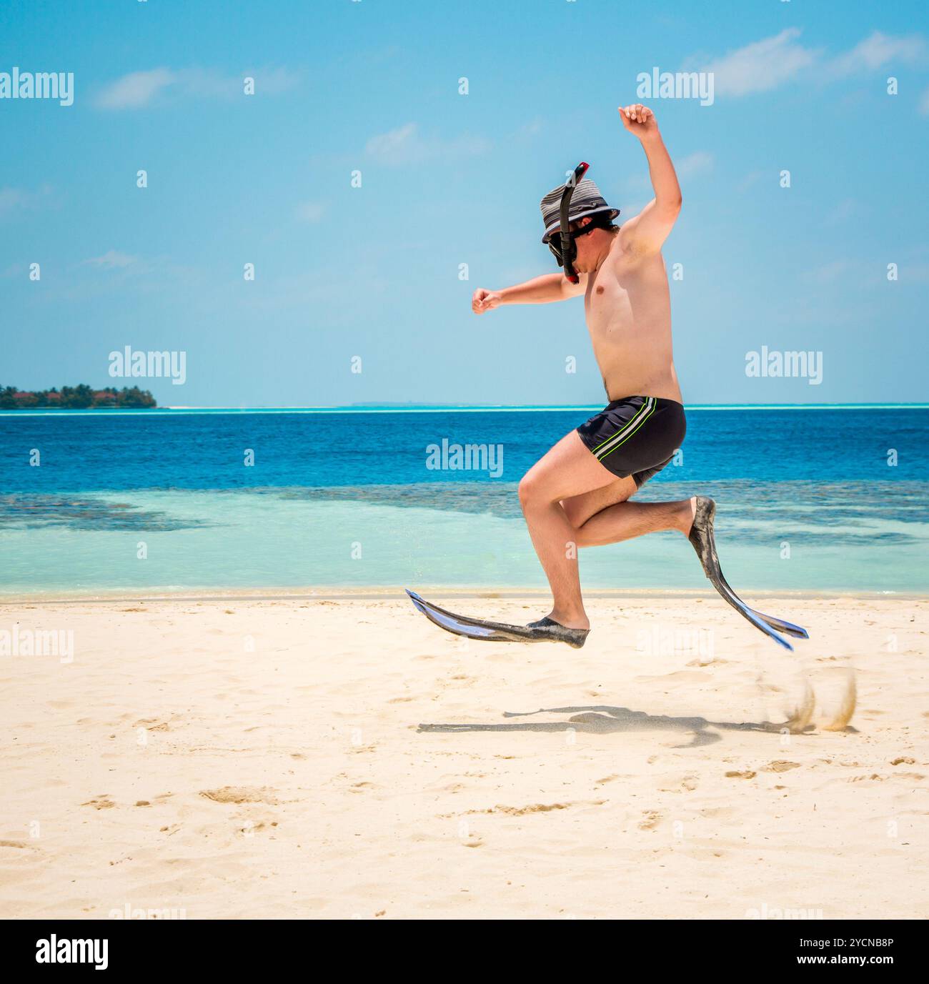 Uomo divertente che salta con le pinne e la maschera. Foto Stock