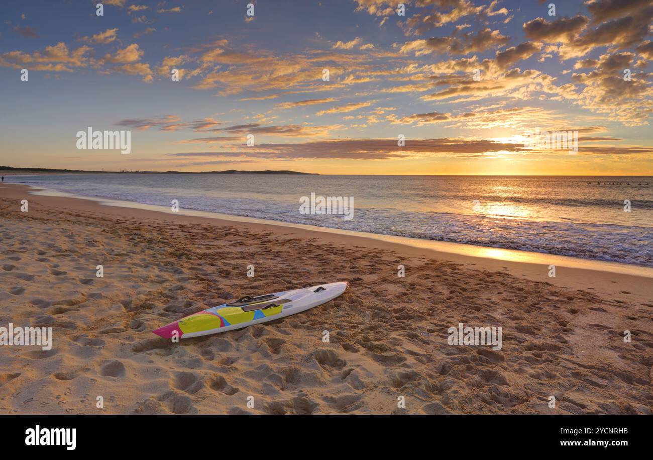 Alba sulla spiaggia e paddleboard sulla costa Foto Stock