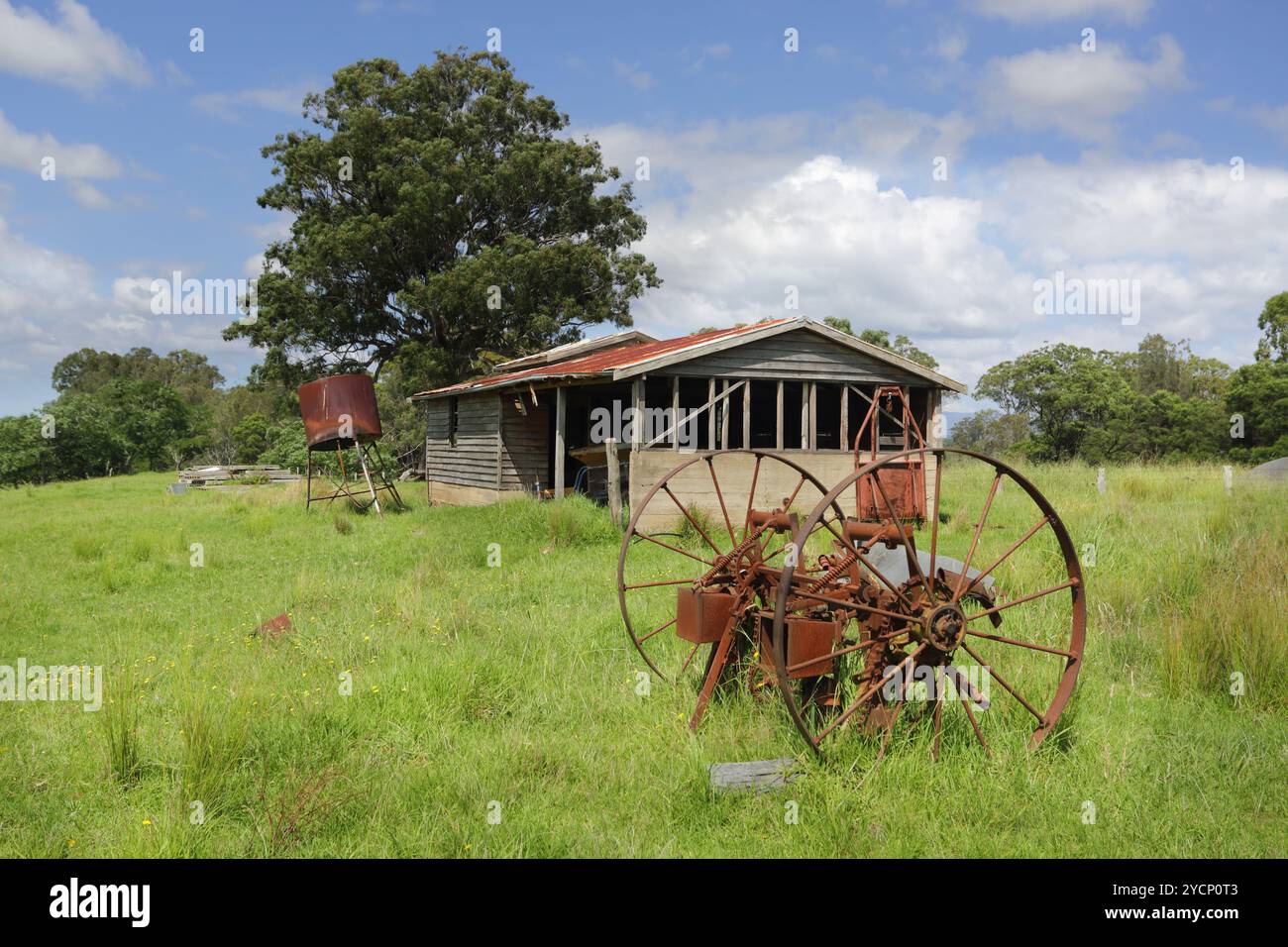 Vecchio capannone abbandonato e ruote arrugginite a Benandarah Foto Stock