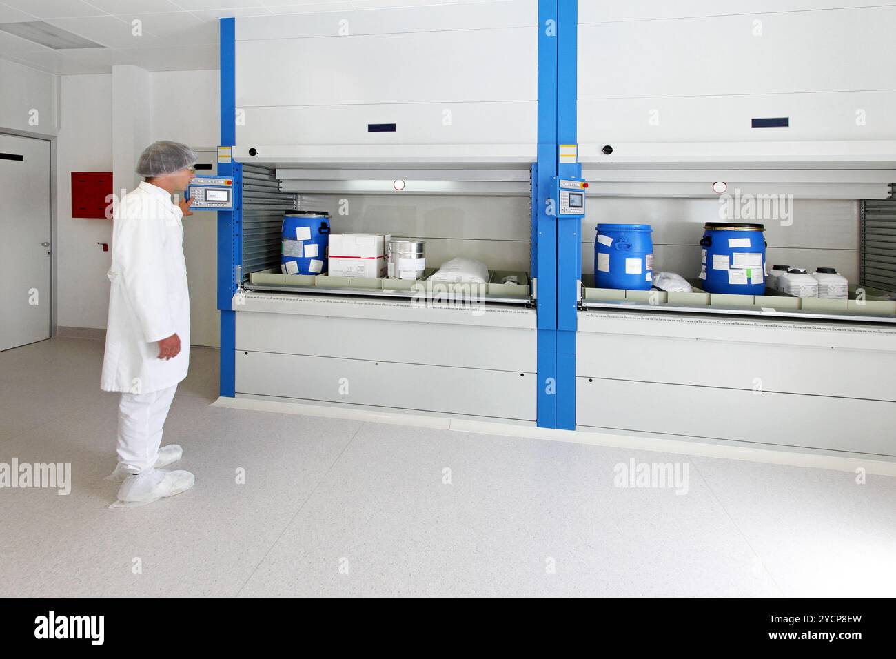 Operatore alla giostra verticale di stoccaggio in magazzino Foto Stock