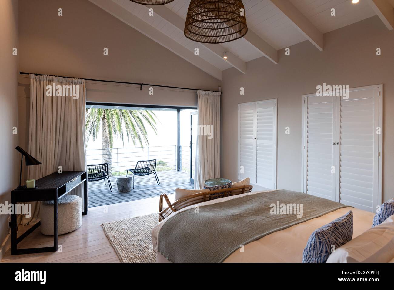 A casa, accogliente camera da letto con vista sull'oceano, arredi eleganti e luce naturale Foto Stock