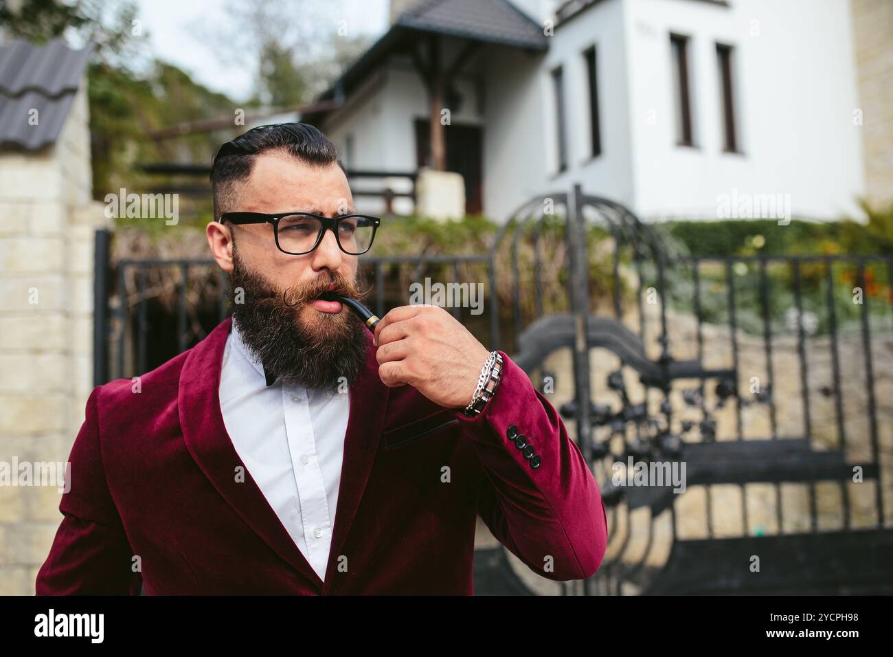 Uomo ricco in una giacca vicino a casa sua Foto Stock