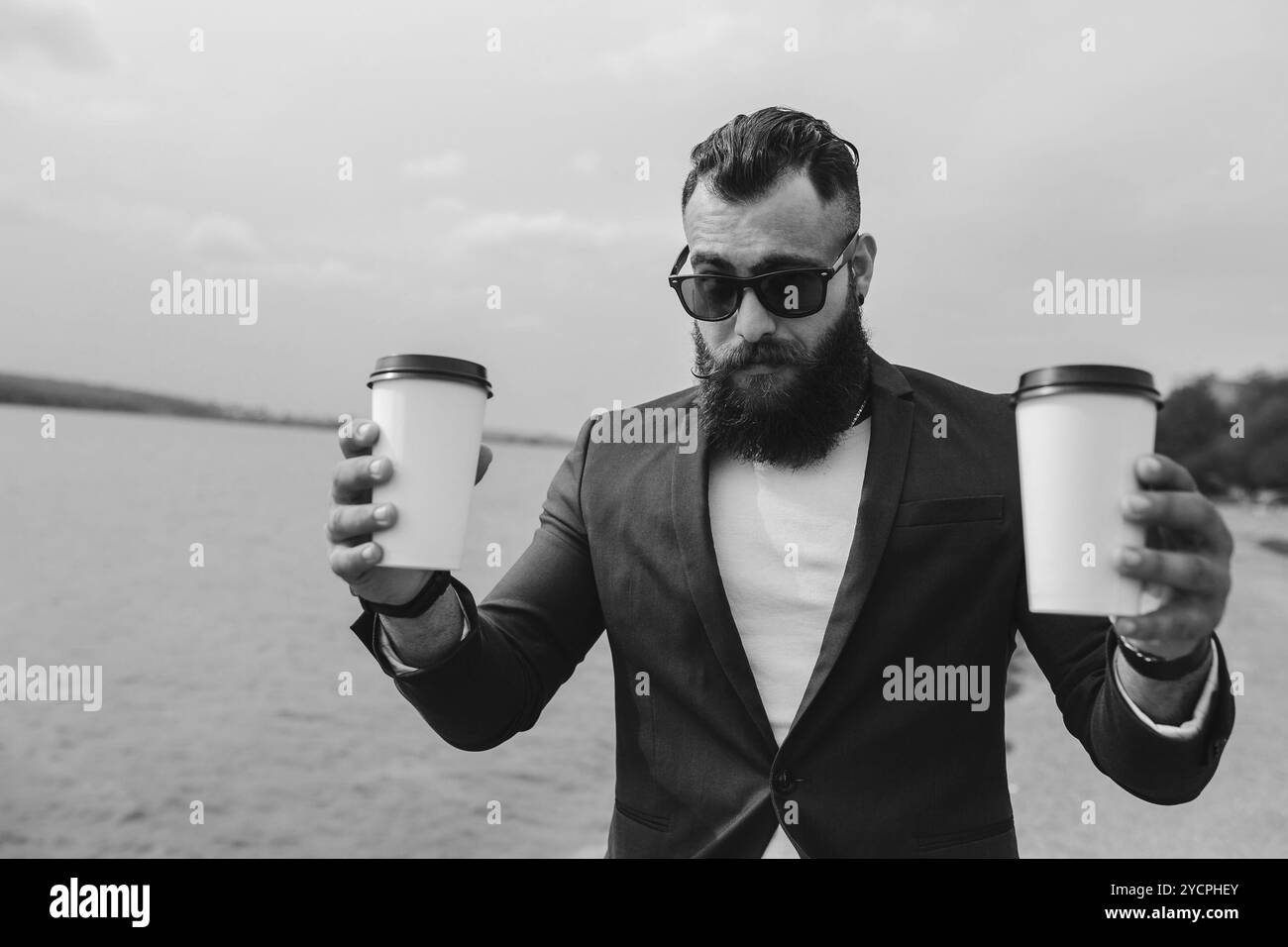 Un uomo ben vestito porta il caffè Foto Stock