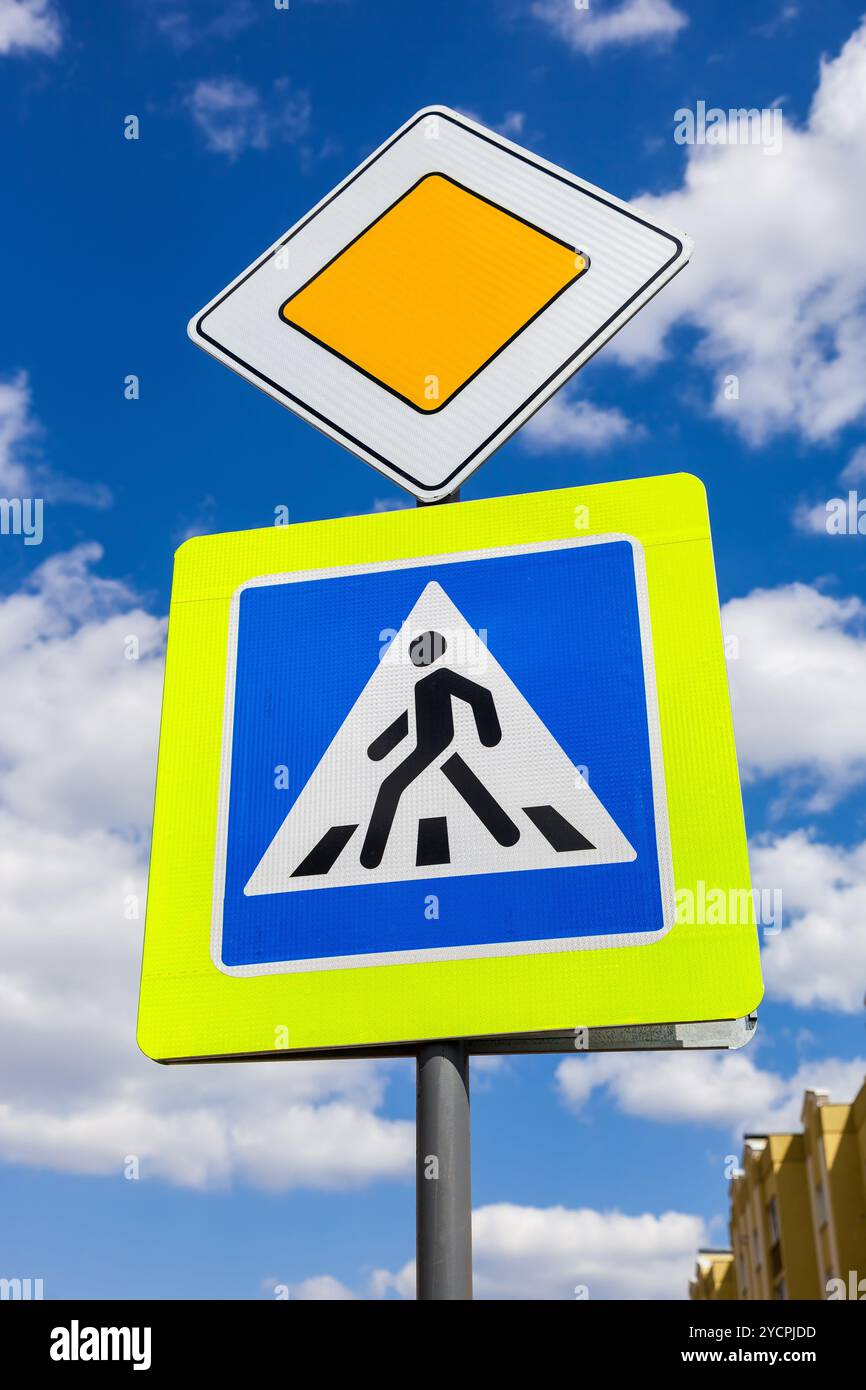 Segnaletica stradale principale e di attraversamento pedonale con le nuvole in background Foto Stock