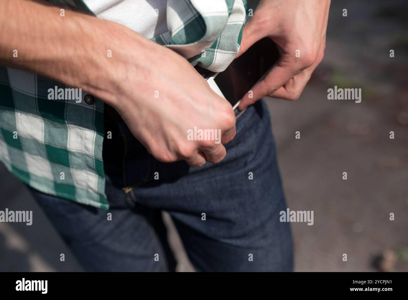 Fiducioso uomo in posa di cimosa jeans Foto Stock