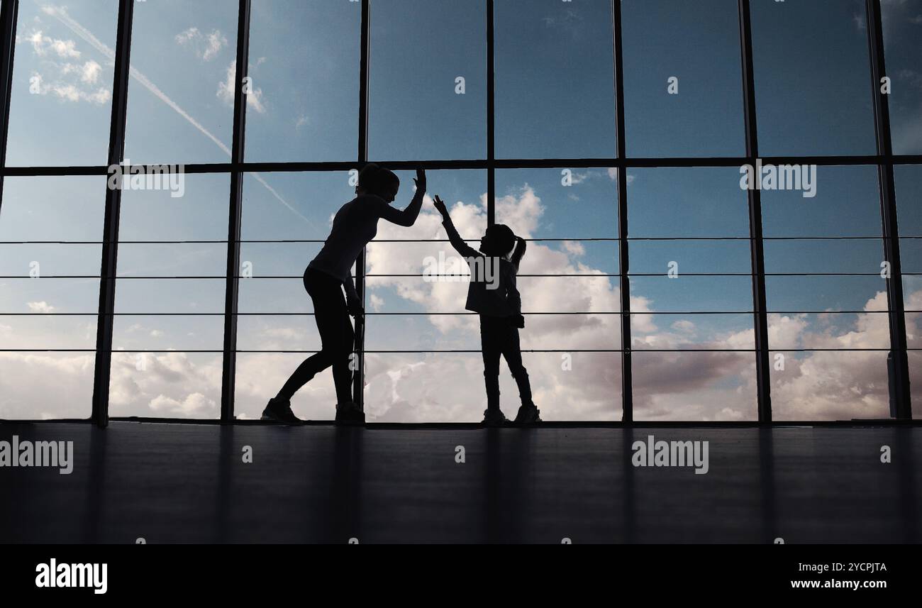 Silhouette di madre e figlia in palestra Foto Stock