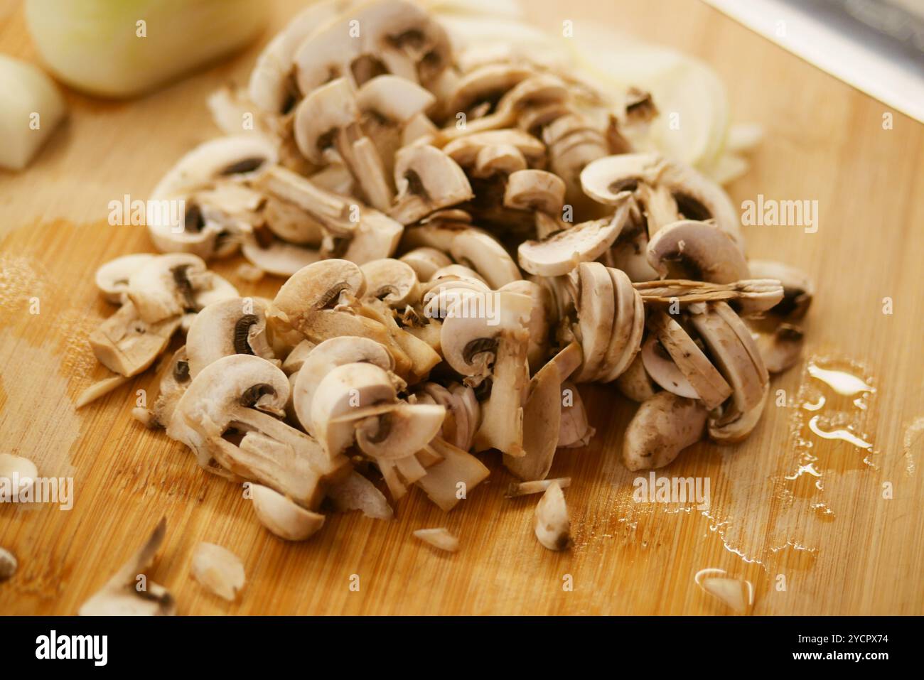 Funghi freschi tritati posti su un tagliere in legno rustico per varie creazioni culinarie Foto Stock