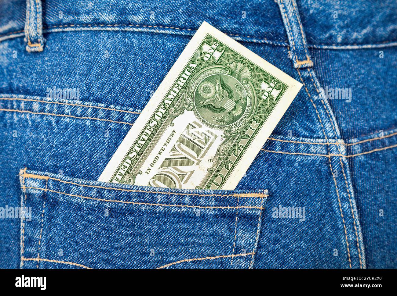 Un dollaro statunitense che sporge dalla tasca dei jeans Foto Stock