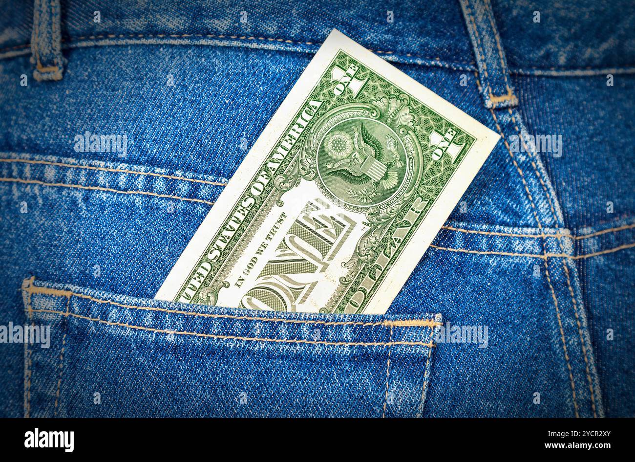 Un dollaro statunitense che sporge dalla tasca dei jeans Foto Stock