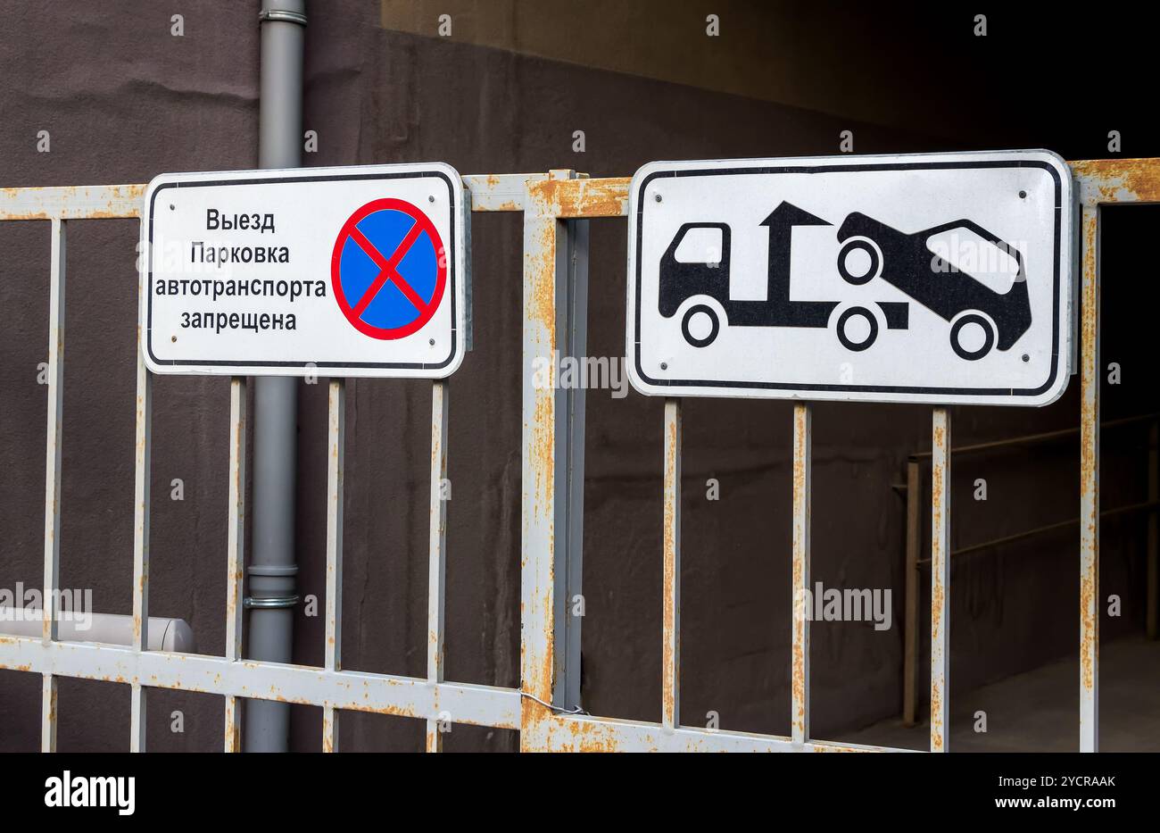 Segnale stradale che vieta il parcheggio montato su un cancello metallico. Evacuazione sul carrello di traino. Testo in russo: Il parcheggio dei veicoli è proibito Foto Stock