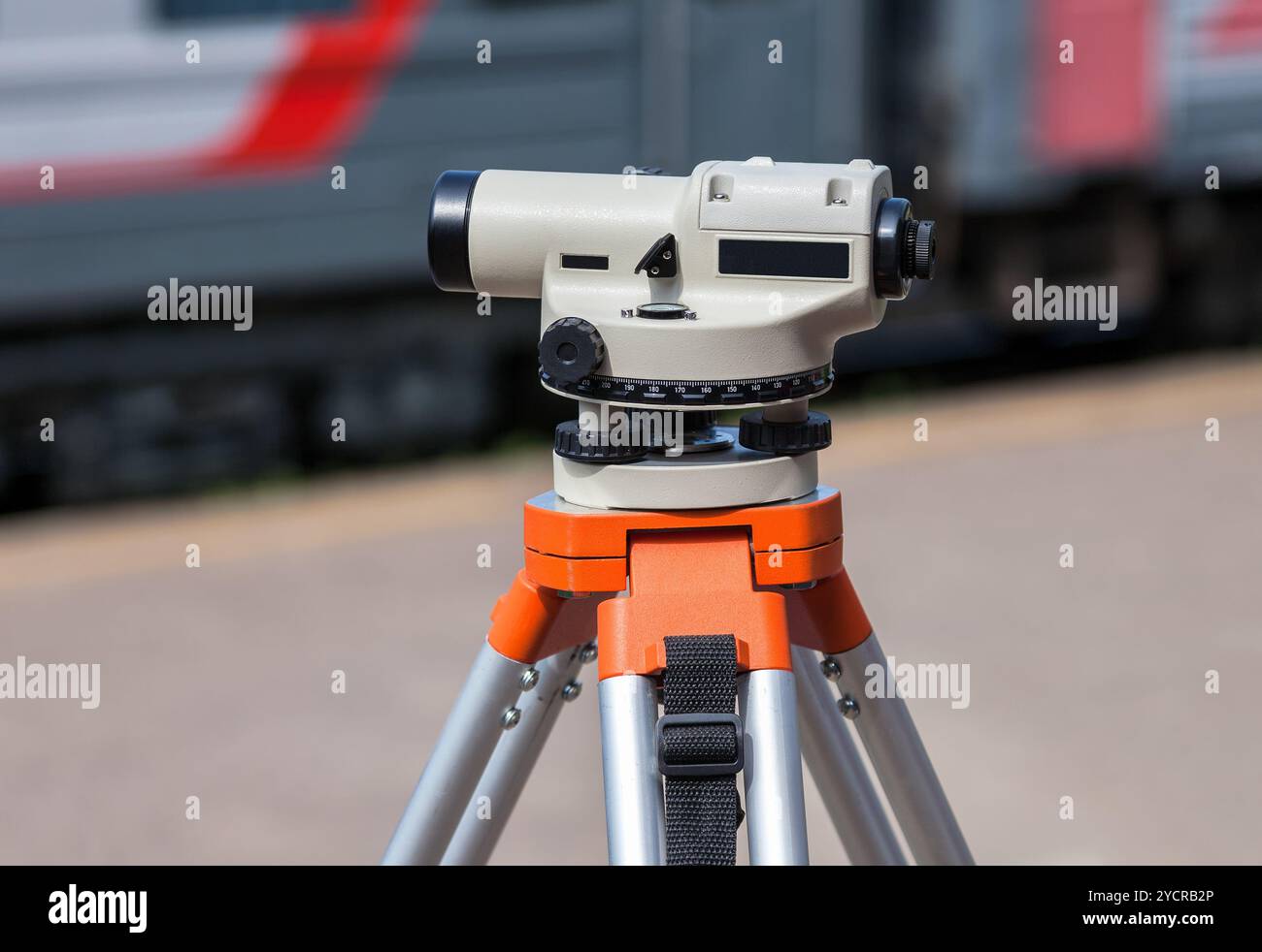 Attrezzature di geodesia livello ottico montato su cavalletto presso la stazione ferroviaria Foto Stock