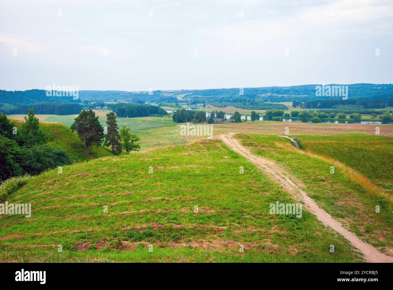 Vista su irriconoscibile la gente a piedi il sentiero su verdi colline. Hill fortezze Kernave, antica capitale lituana Foto Stock