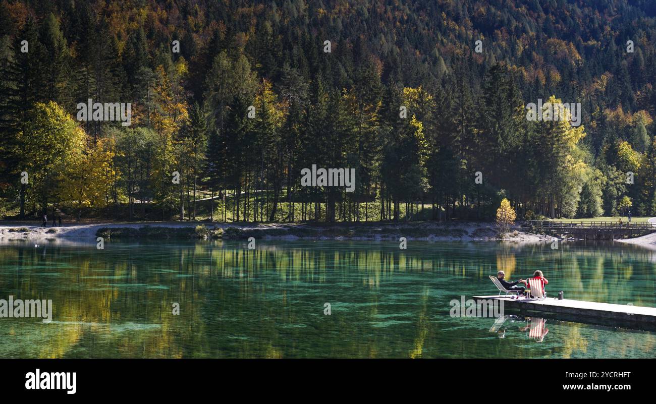 Kranjska Gora, Slovenia, 18 ottobre 2021: I turisti si rilassano sul molo di legno del lago Jasna, nelle Alpi slovene, in Europa Foto Stock