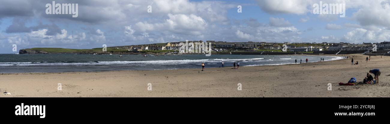 Kilkee, Irlanda, 4 agosto 2022: Le persone godono di una calda giornata estiva sulla spiaggia di sabbia dorata di Kilkee nell'Irlanda occidentale, in Europa Foto Stock