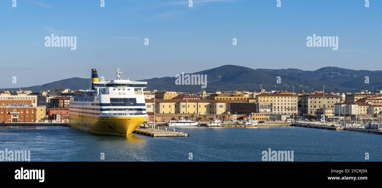 Livorno, Italia, 1 dicembre 2022: Traghetto passeggeri di grandi dimensioni nel porto di Livorno con il centro storico e il lungomare alle spalle, Europa Foto Stock