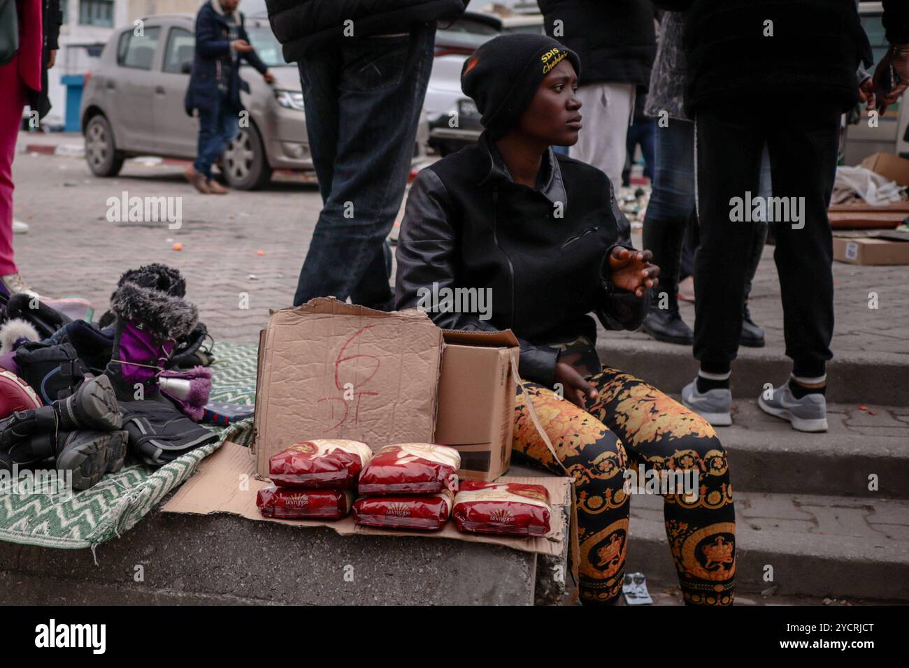 Tunisi, Tunisia. 17 febbraio 2024. Un migrante subsahariano residente in Tunisia vende stivali e couscous da una stalla a Tunisi. Migliaia di migranti provenienti da paesi africani al di fuori del Nord Africa vivono e lavorano in Tunisia, con la maggior parte del loro lavoro nel settore informale. Eppure, con l'aumento delle tensioni in Tunisia dall'inizio del 2023, molti migranti cercano di risparmiare abbastanza denaro per intraprendere il pericoloso viaggio in barca verso l'isola italiana di Lampedusa Foto Stock