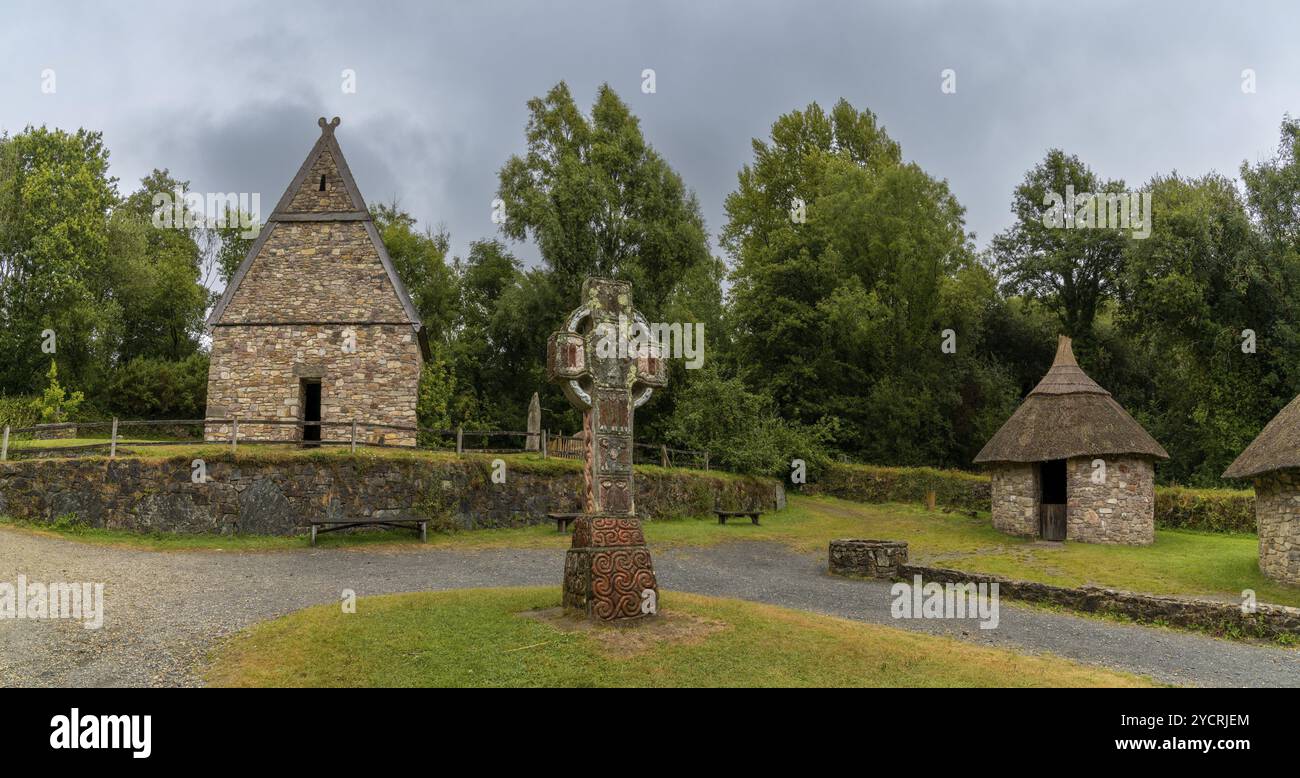 Wexford, Irlanda, 18 agosto 2022: Veduta di un monastero cristiano ricostruito all'inizio nel National Heritage Park irlandese con una grande croce celtica dentro Foto Stock
