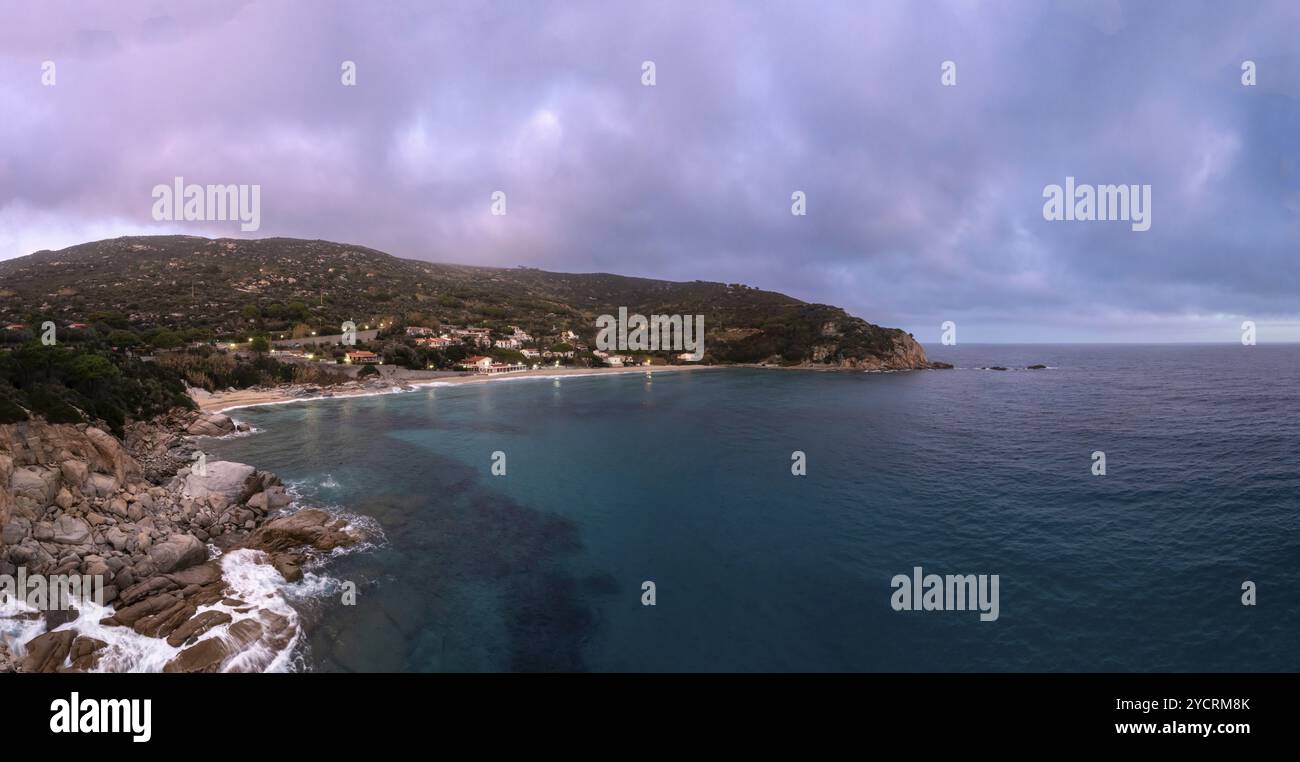 Una vista droni della Spiaggia di Cavoli sull'Isola d'Elba subito dopo il tramonto con un cielo viola nebbioso Foto Stock