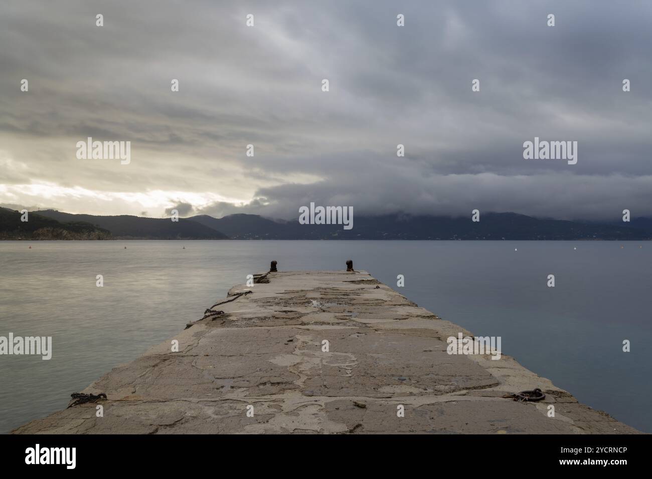 Una vista del molo di pietra che conduce all'oceano a Enfola Beach sull'Isola d'Elba Foto Stock