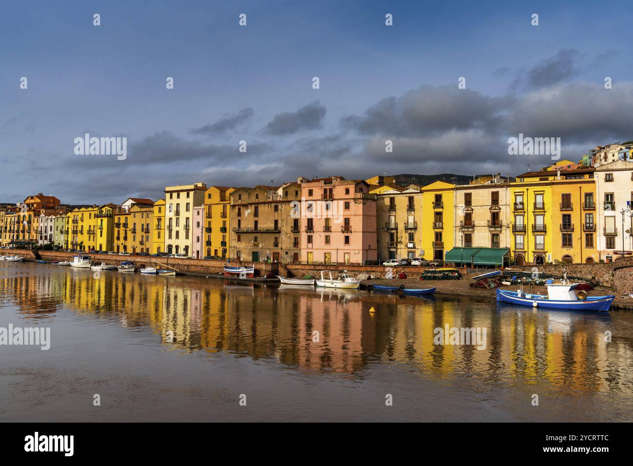 Bosa, Italia, 13 dicembre 2022: Case colorate e barche da pesca sul lungomare di Bosa sul fiume Terno, Europa Foto Stock
