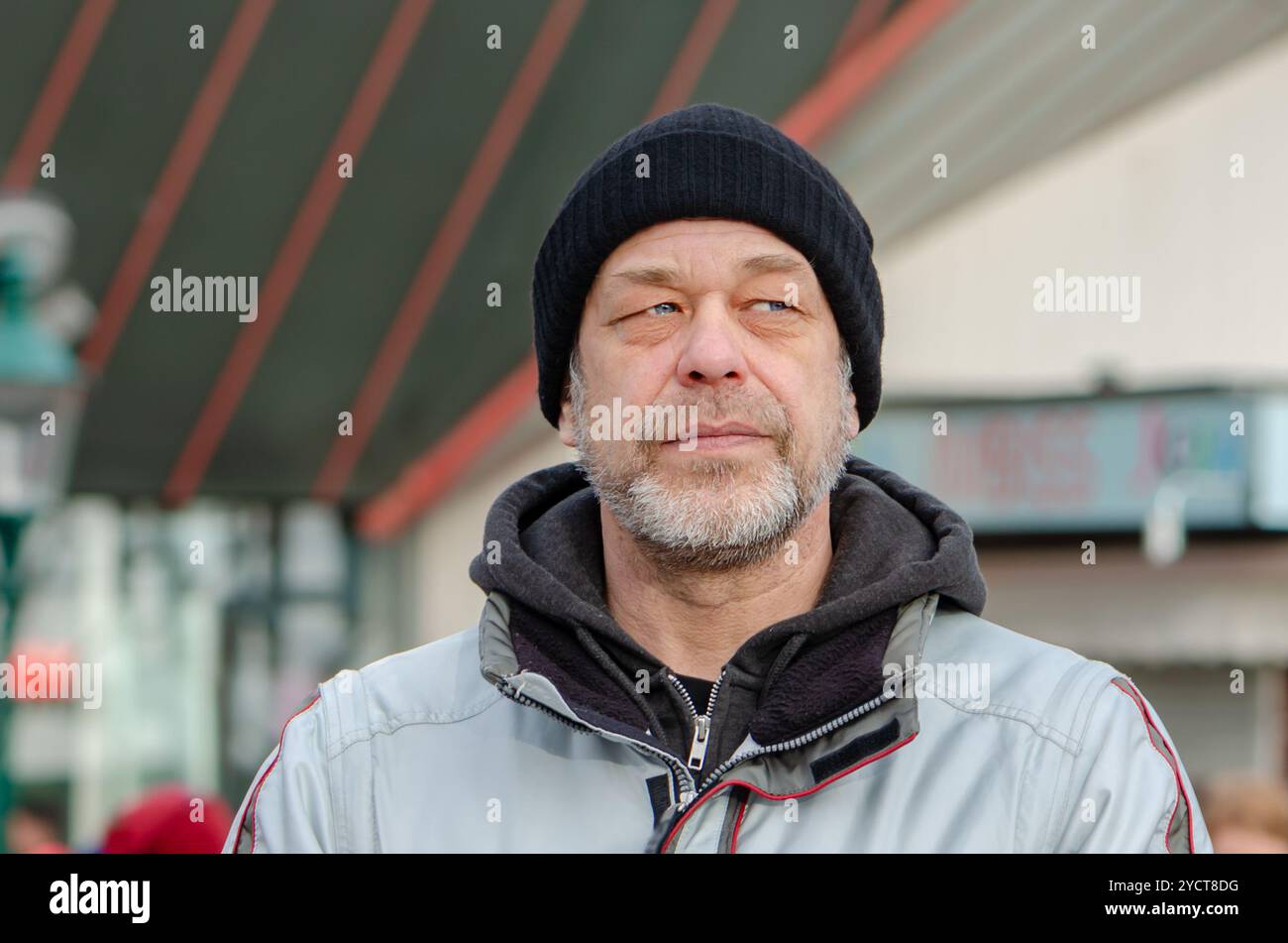 Ritratto di un uomo ANNOIATO di 50-55 anni in uno sfondo urbano sfocato. Foto Stock