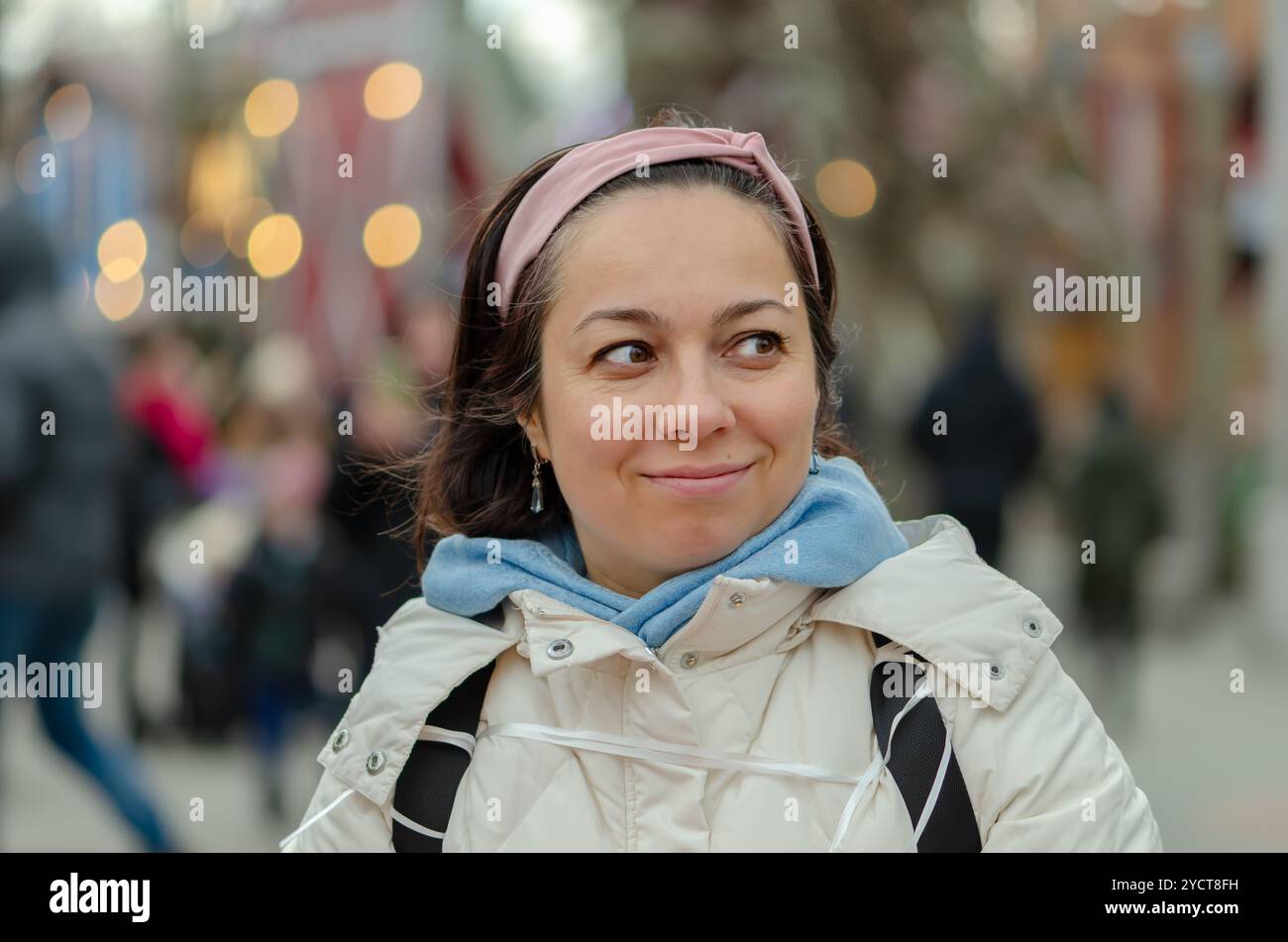 Bella donna dall'aspetto orientale di 40 - 45 anni sullo sfondo di un paesaggio urbano sfocato. Foto Stock