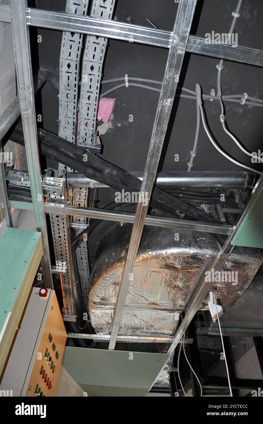 Passacavi e canaline metalliche all'interno dello spazio del controsoffitto di un progetto di costruzione. Foto Stock