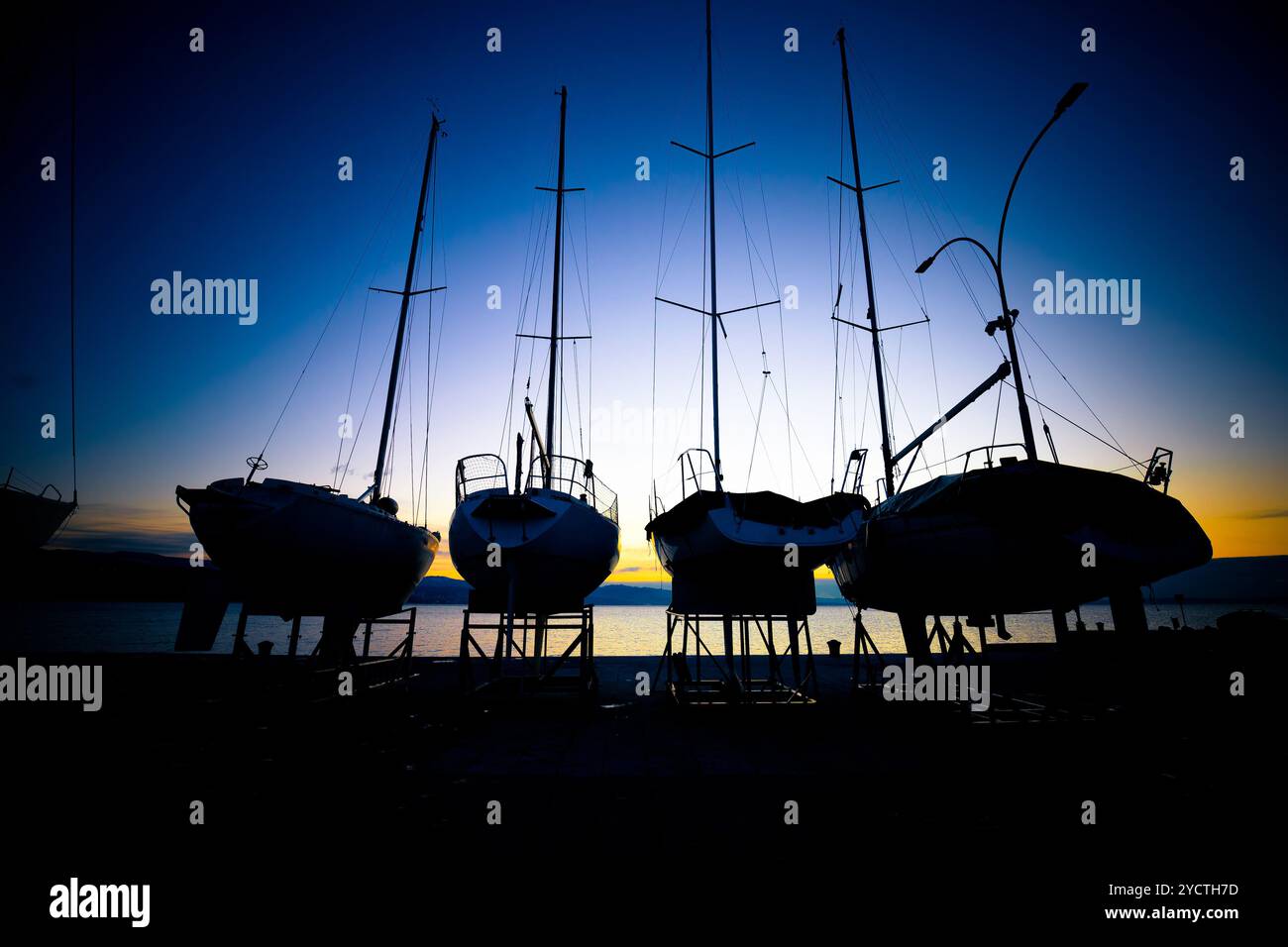 Barche a vela in bacino di carenaggio vista sunrise Foto Stock