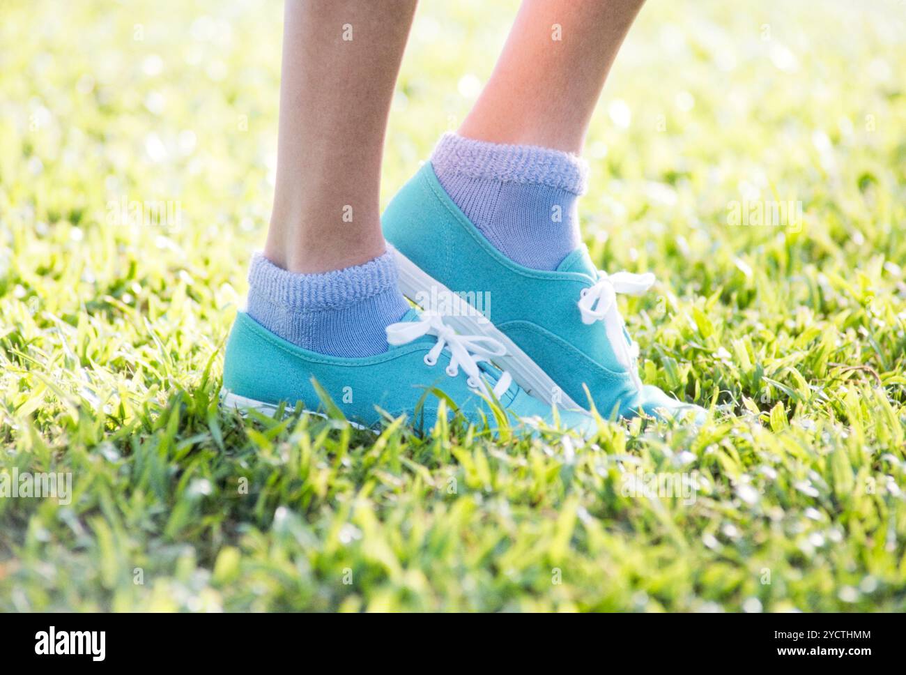 Passi che camminano su scarpe da ginnastica sul prato Foto Stock