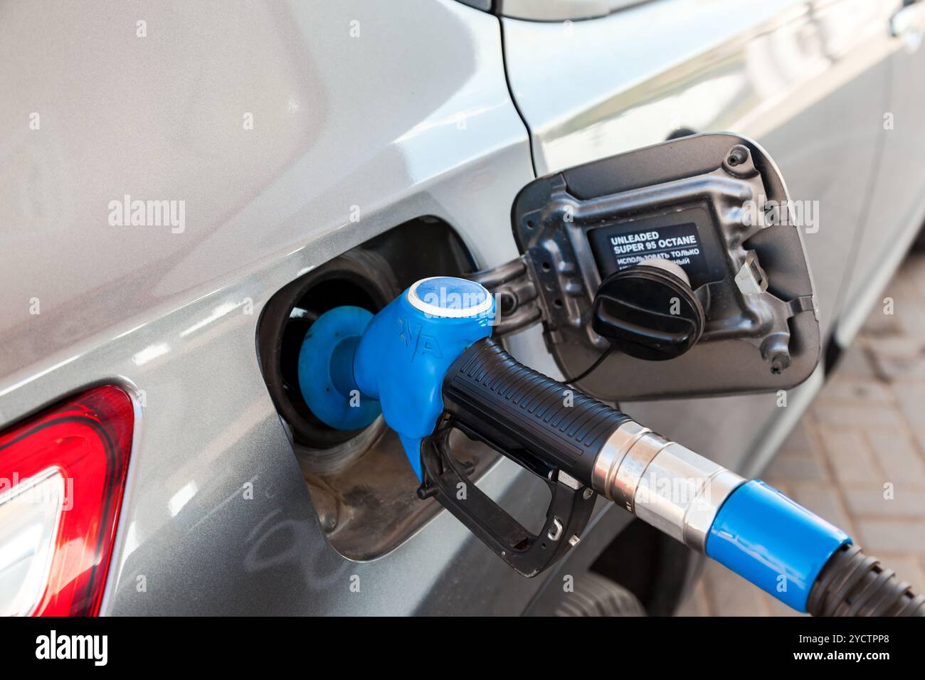 Ugello del carburante per scaricare il carburante nell'autovettura presso la stazione di servizio Foto Stock