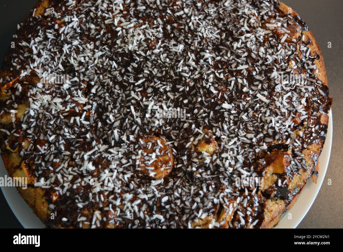 Torte fatte con le tue mani. Torta "Chocolate" composta da impasto per biscotti, crema di burro al cioccolato, decorata con scaglie di cocco e glassa al cioccolato. Foto Stock