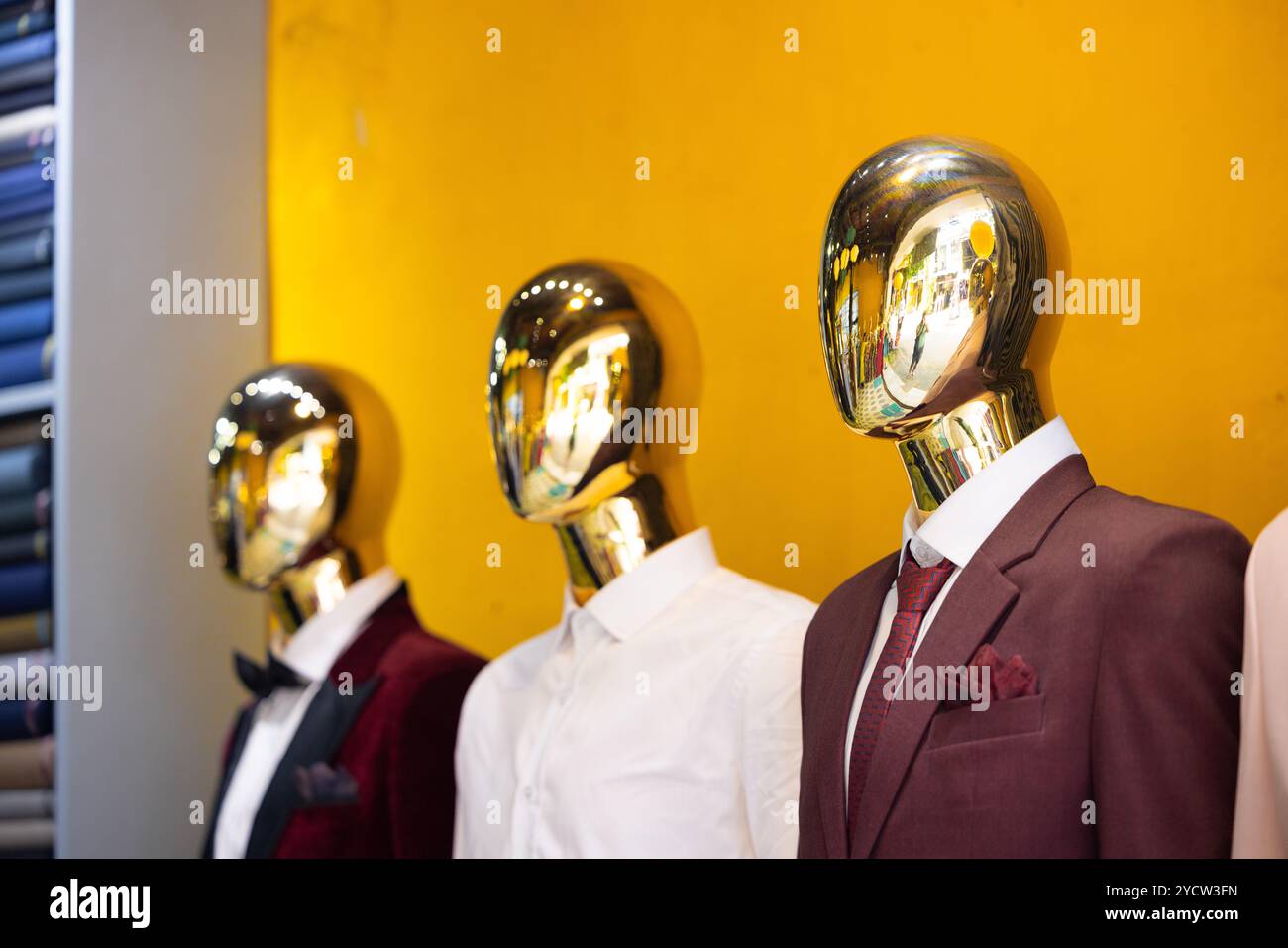 I manichini con teste dorate sembrano robot android in abiti da lavoro. Foto Stock I manichini con teste dorate sembrano robot android in abiti da lavoro. Foto Stock