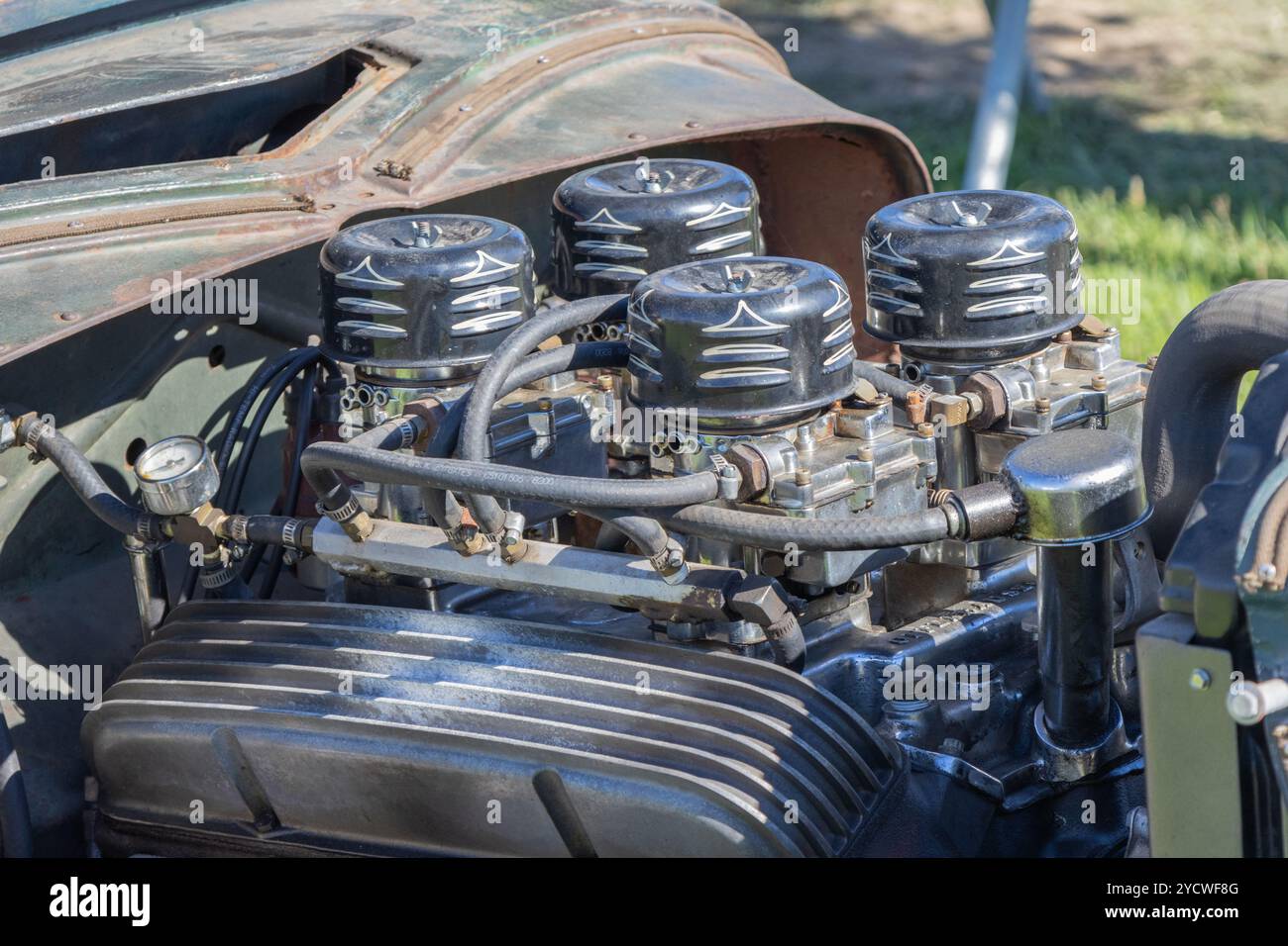 Il potente motore v8 personalizzato con quattro carburatori risplende al sole e mostra dettagli meccanici Foto Stock