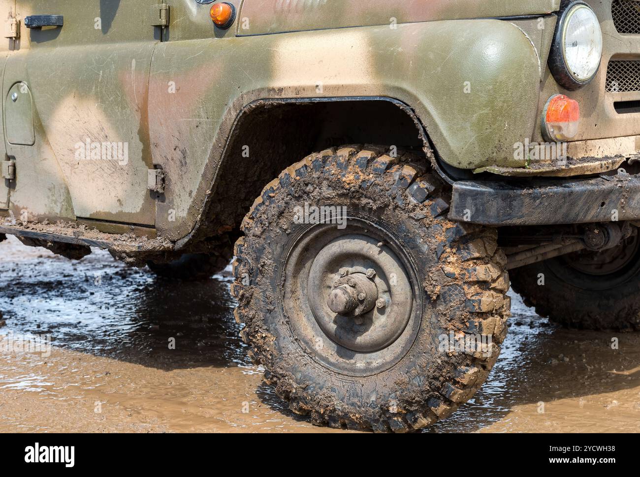 Estremamente sporco SUV ruota dopo la guida sotto la pioggia su sporco strada rurale Foto Stock