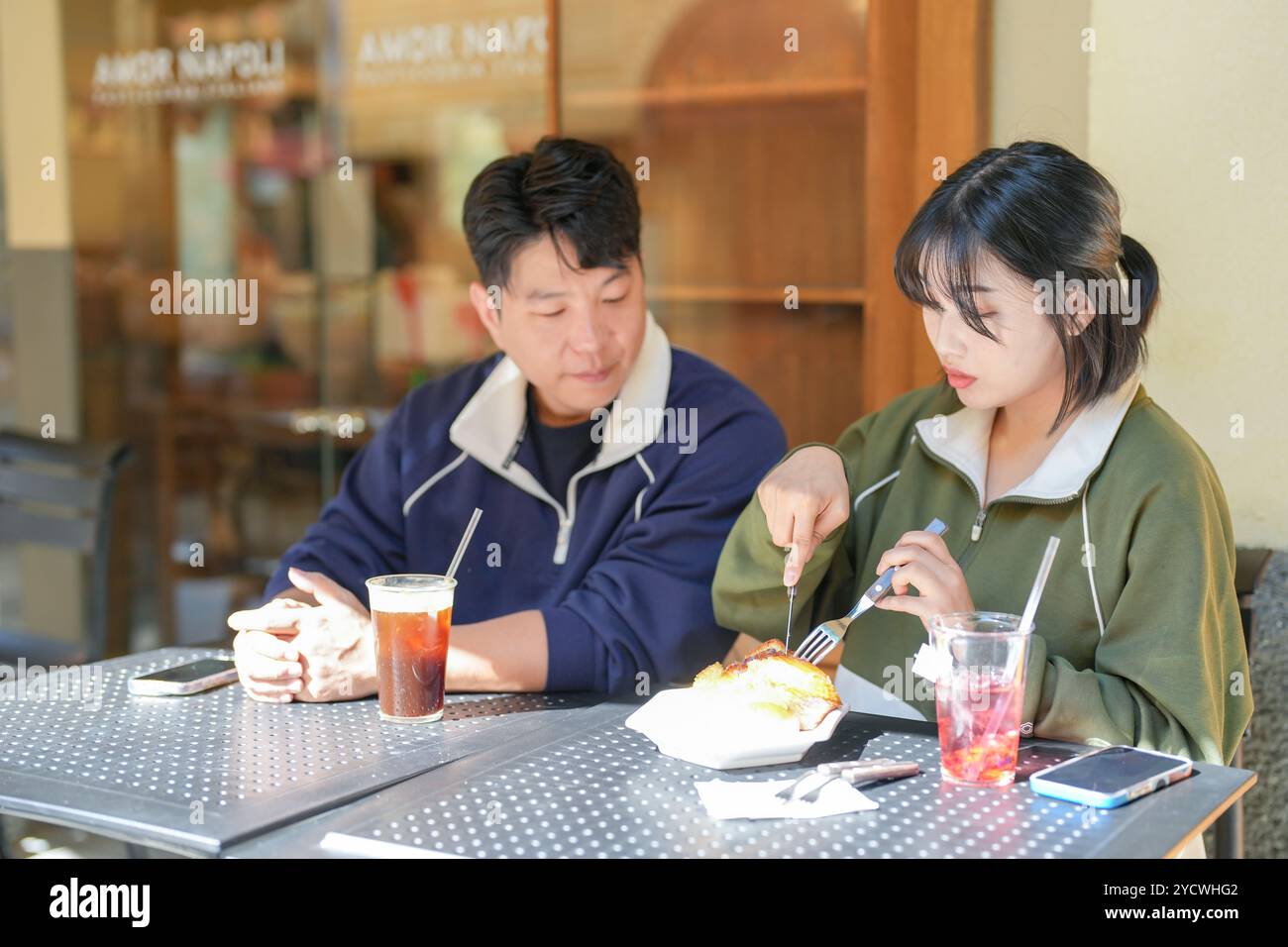 Una coppia, un uomo coreano di 30 anni e una donna di 20 anni, indossa tute e goditi un pomeriggio in un bel caffè in stile occidentale a Seoul, Corea del Sud. Foto Stock