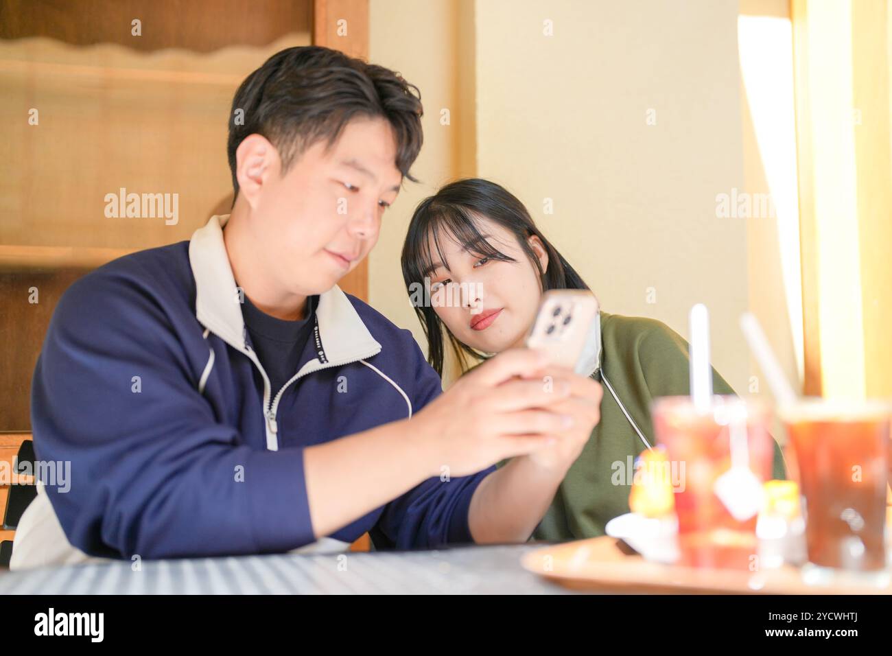 Una coppia, un uomo coreano di 30 anni e una donna di 20 anni, indossa tute e goditi un pomeriggio in un bel caffè in stile occidentale a Seoul, Corea del Sud. Foto Stock