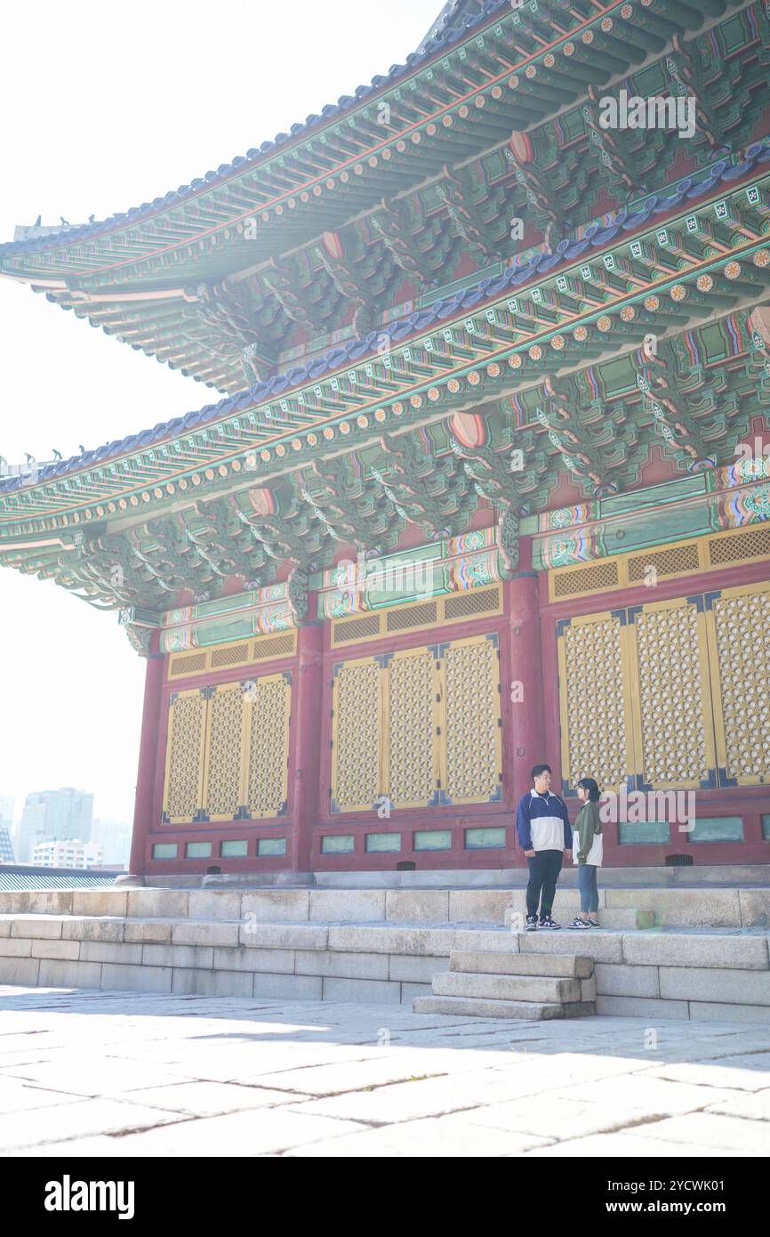 Una coppia coreana sportiva, un uomo di 30 anni e una donna di 20 anni, che indossa tute, trascorrono il loro tempo insieme felicemente in un edificio storico di se Foto Stock