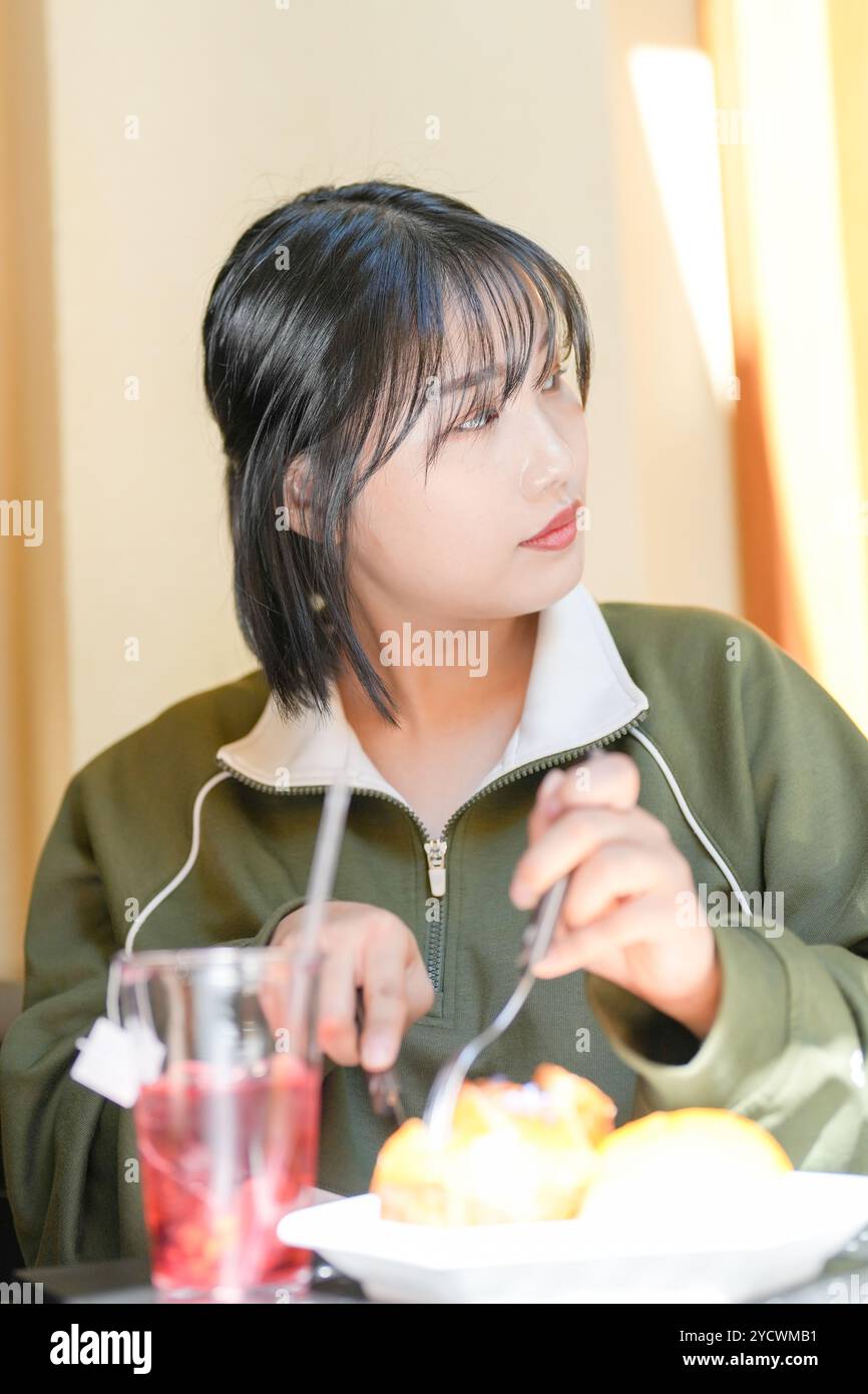 Una coppia, un uomo coreano di 30 anni e una donna di 20 anni, indossa tute e goditi un pomeriggio in un bel caffè in stile occidentale a Seoul, Corea del Sud. Foto Stock