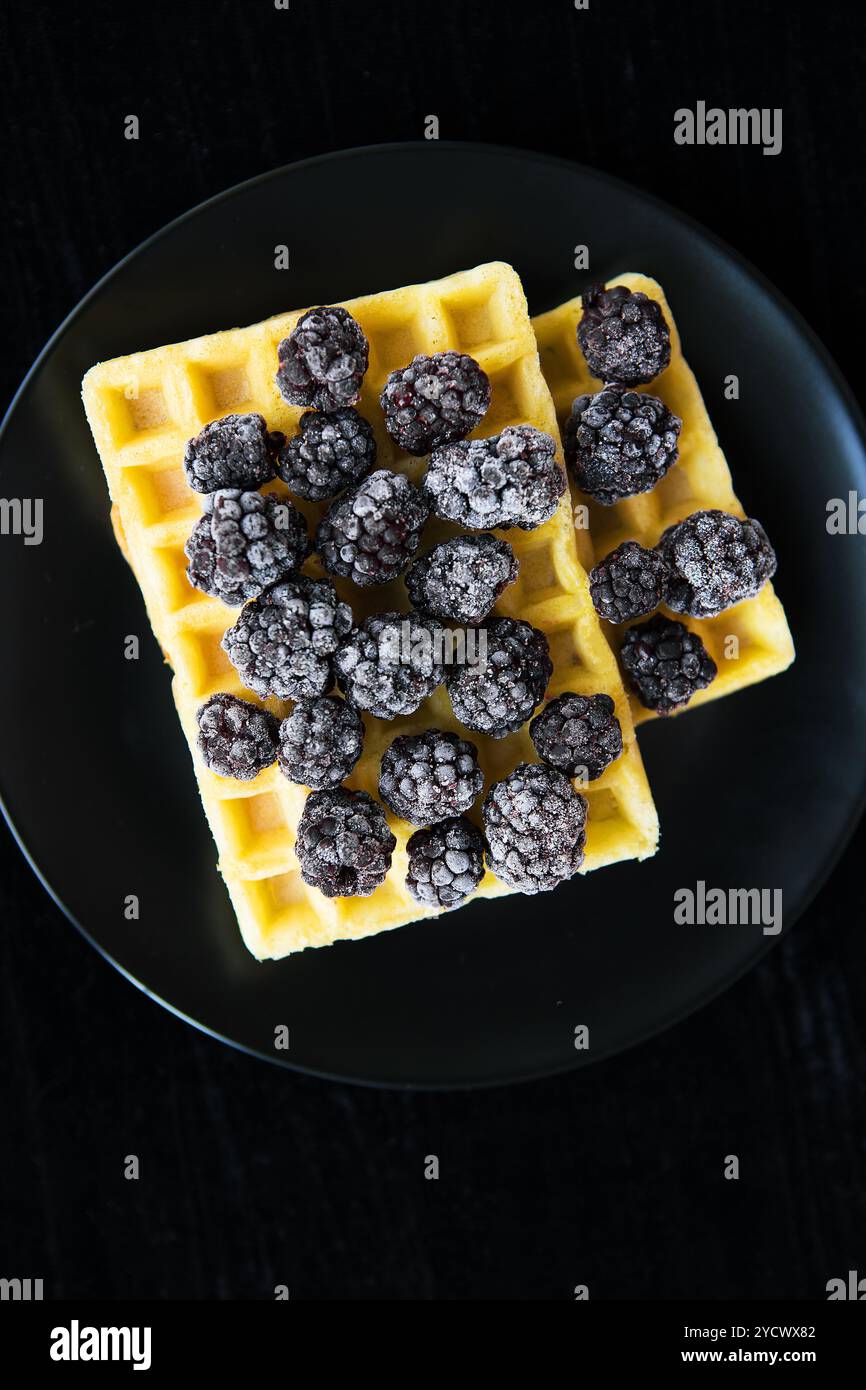 Cialde belghe con congelati more su sfondo nero Foto Stock