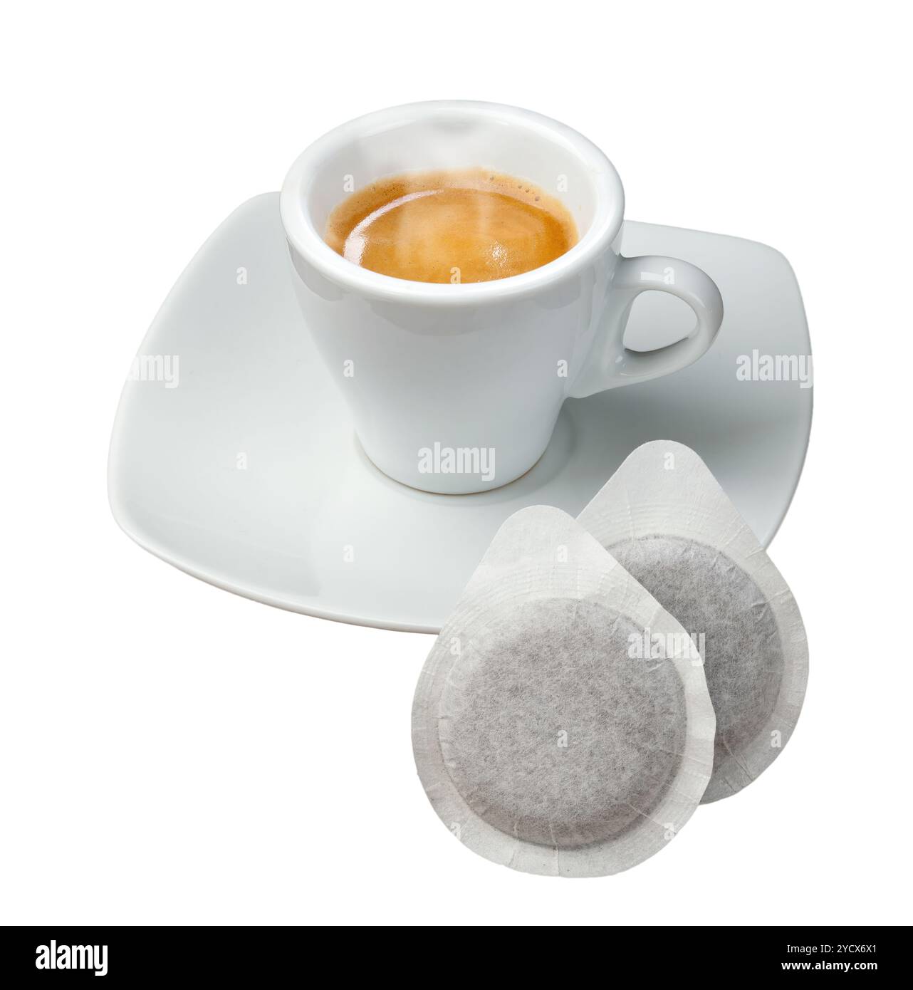 Una tazza di caffè fumante si trova su un piattino bianco con due cialde di caffè appoggiate in primo piano Foto Stock