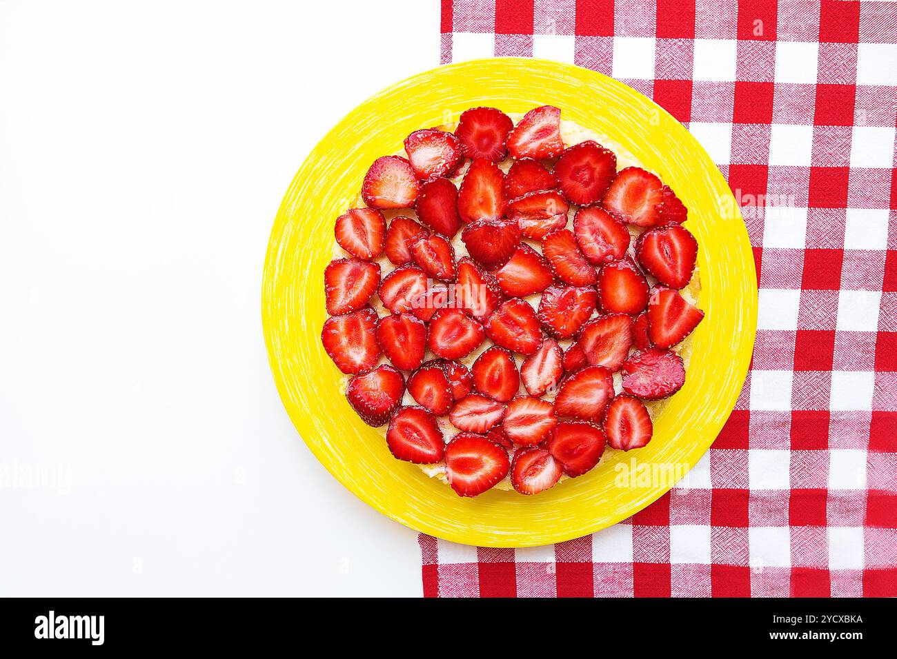 Luminose e una deliziosa torta di fragole su un tovagliolo rosso in una gabbia Foto Stock