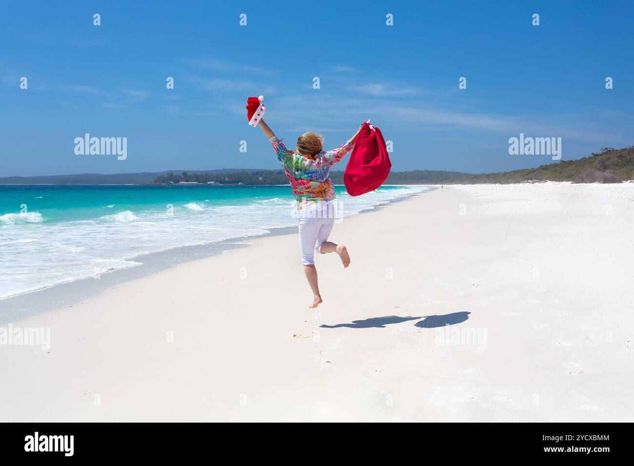 Festeggia il Natale in Australia - le donne saltano per gioia sulla spiaggia Foto Stock